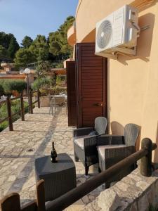 a patio with chairs and tables and a building at Un Tuffo nel Blu in Sperlonga