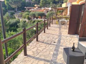 a stone walkway with a wooden fence and a table at Un Tuffo nel Blu in Sperlonga