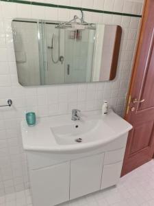 a bathroom with a white sink and a mirror at Un Tuffo nel Blu in Sperlonga +8 photos