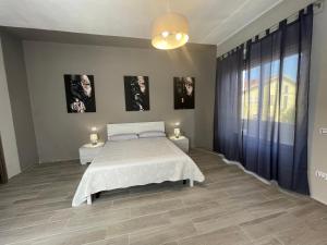 カルボーニアにあるAPPARTAMENTO ELEGANTE CARBONIAのベッドルーム1室(ベッド1台、ナイトスタンド2台、窓付)