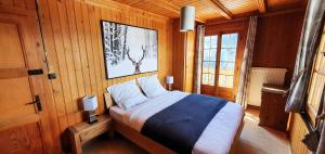 a bedroom with a bed in a wooden cabin at Auberge le Mont-Gelé in Iserables