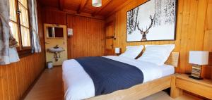 una camera da letto con un grande letto in una camera in legno di Auberge le Mont-Gelé a Iserables