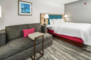 una camera d'albergo con letto e divano di Hampton Inn Wilson Downtown a Wilson
