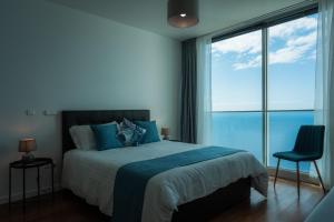 een slaapkamer met een bed en uitzicht op de oceaan bij Sea View Villa Mar Lindo nr Ponta do Sol in Ponta do Sol