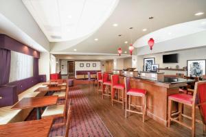 a restaurant with a bar and red chairs at Hampton Inn Richmond - Airport in Sandston