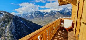 d'un balcon avec une chaise et une vue sur les montagnes. dans l'établissement Auberge le Mont-Gelé, à Iserables