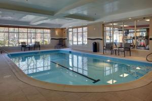 a large swimming pool with chairs and tables in a building at Hampton Inn Richmond - Airport in Sandston