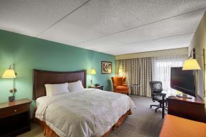 a hotel room with a bed and a flat screen tv at Hampton Inn Raleigh/Garner in Garner