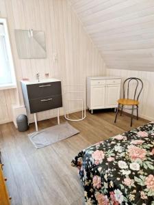 a bedroom with a bed and a sink and a chair at Gîte La Scierie, Maison Familiale, Laguiole in Laguiole