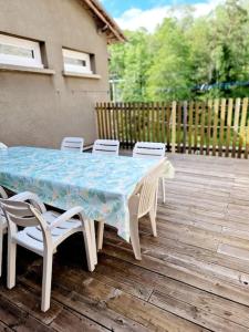 a table and chairs sitting on a wooden deck at Gîte La Scierie, Maison Familiale, Laguiole in Laguiole