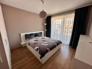 une chambre avec un lit et une grande fenêtre dans l'établissement Apartament Sianna, à Mamaia