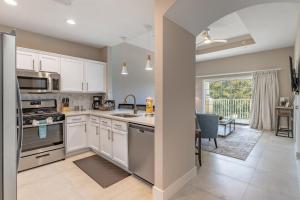 een keuken met witte kasten en een groot raam bij Modern Luxury Retreat in Kissimmee