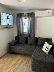 a living room with a couch and a flat screen tv at Lily B in Pakoštane