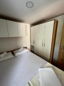 a bedroom with two beds and white cabinets at Lily B in Pakoštane