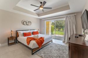 een slaapkamer met een bed, een bureau en een raam bij Modern Luxury Retreat in Kissimmee +33 foto's