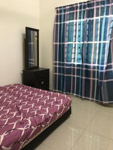 1 dormitorio con cama, tocador y espejo en Homestay Dalilah Islam Sendayan, en Seremban