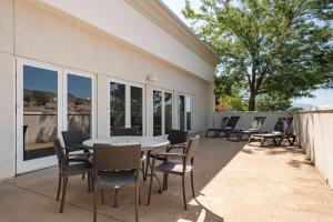 eine Terrasse mit einem Tisch, Stühlen und Fenstern in der Unterkunft Hampton Inn Richfield in Richfield