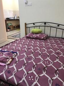 1 cama con edredón púrpura y almohadas en Homestay Dalilah Islam Sendayan, en Seremban
