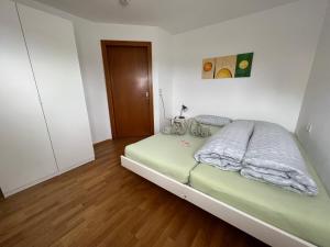 a bedroom with a green bed with a wooden floor at Apartment Riedwiese in Hörbranz