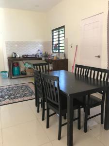 una mesa de comedor negra y sillas en la cocina en Homestay Dalilah Islam Sendayan, en Seremban