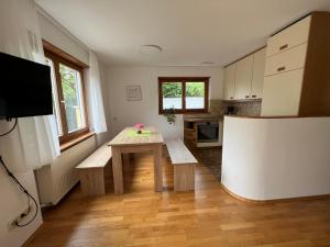 een kleine keuken met een houten tafel en een bank. bij Apartment Riedwiese in Hörbranz