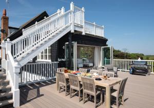 eine Terrasse mit einer Treppe und einem Tisch mit Stühlen in der Unterkunft The Pavilion in Orford