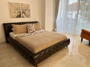 a bed with a leather headboard in a room at Marini Casa in Ulcinj