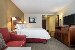 a hotel room with a bed and a flat screen tv at Hampton Inn Roanoke/Hollins - I-81 in Roanoke