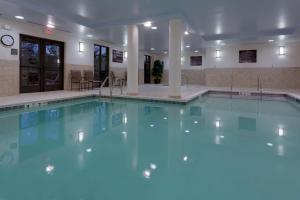 una piscina con agua azul en un edificio en Hampton Inn Rochester-Webster, en Webster
