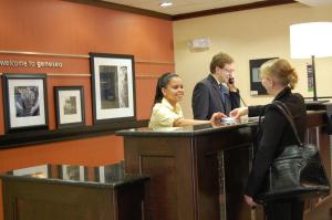 a man and a woman standing at a reception desk at Hampton Inn Geneseo in Geneseo