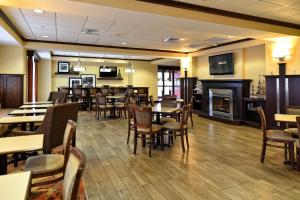 a restaurant with tables and chairs and a fireplace at Hampton Inn Geneseo in Geneseo