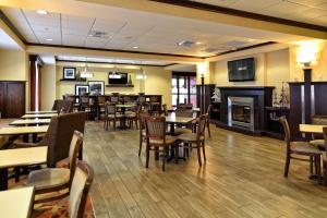 un restaurante con mesas y sillas y una chimenea en Hampton Inn Geneseo, en Geneseo