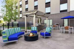 a patio with chairs and a fire pit and a building at Hampton Inn & Suites Rogers in Rogers