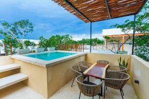 a patio with a table and chairs and a swimming pool at Amazing 3Br & Private Patio With Pool in Tulum in Tulum