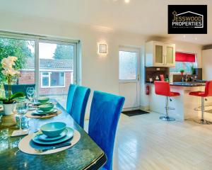 a dining room with a table and blue chairs at Large 6 Bedroom Contractor House by Jesswood Properties Short Lets For Groups, Business And Leisure With Free Parking, Wifi and Pool Table in Luton
