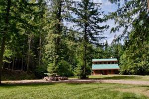 une maison au milieu d'un champ arboré dans l'établissement 2 Adjacent Cabins near Silverwood - Serene, Private and Forested, à Spirit Lake