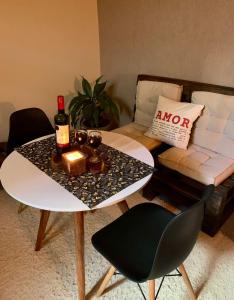 a living room with a table with a bottle of wine at Suíte 100m da praia e academia inclusa dias de semana in Maceió