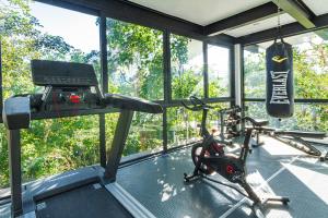 una sala con gimnasio con cinta de correr y simulador en Amazing 3Br & Private Patio With Pool in Mun 32 Tulum, en Tulum
