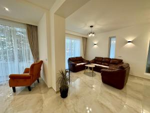 a living room with couches and a table and chairs at Marini Casa in Ulcinj
