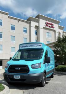 una furgoneta azul estacionada frente a un edificio en Hampton Inn & Suites Rochester-North, en Rochester