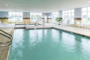 a large swimming pool with blue water in a building at Hampton Inn & Suites Rochester-North in Rochester