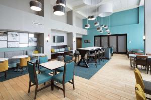 a dining room with tables and chairs and a cafeteria at Hampton Inn & Suites Rochester-North in Rochester