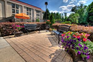 dos bancos y flores frente a un edificio en Hampton Inn Rocky Mount, en Rocky Mount