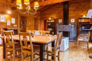 una sala da pranzo con tavolo in legno e camino di BOG Las Lomitas a Villa La Angostura