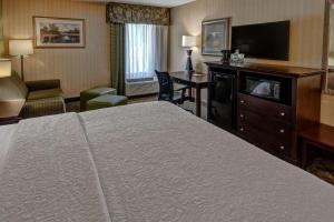 a hotel room with a bed and a flat screen tv at Hampton Inn Rocky Mount in Rocky Mount