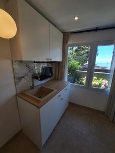 a kitchen with a sink and a large window at Apartment Melany in Senj