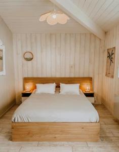 a bedroom with a large bed with two night stands at La cabane de Mamie classée 4 étoiles à 150m de la plage 2 chambres 3 lits in Biscarrosse