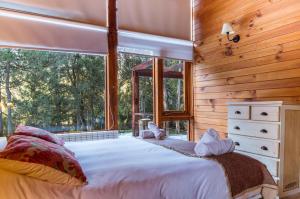 1 dormitorio con cama grande y ventana grande en BOG Las Lomitas en Villa La Angostura