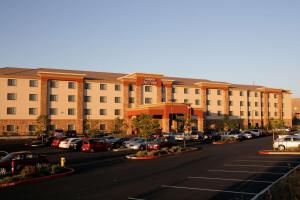 um grande hotel com carros estacionados num parque de estacionamento em Hampton Inn & Suites Folsom em Folsom