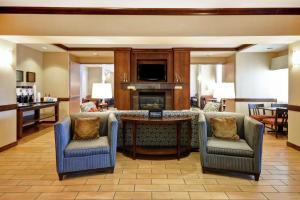 a living room with chairs and a table with a fireplace at Hampton Inn & Suites Folsom in Folsom